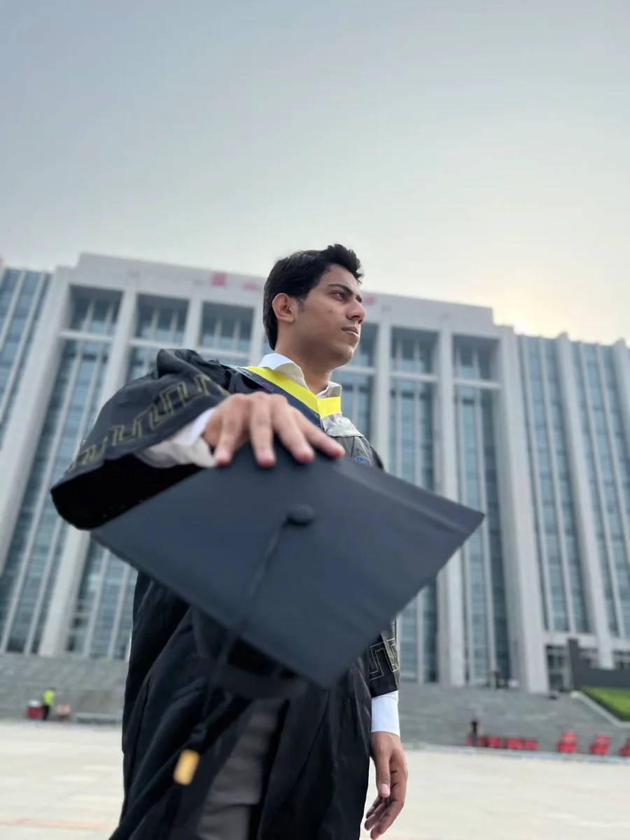 Ali Khan in graduation attire outside North China Electric Power University